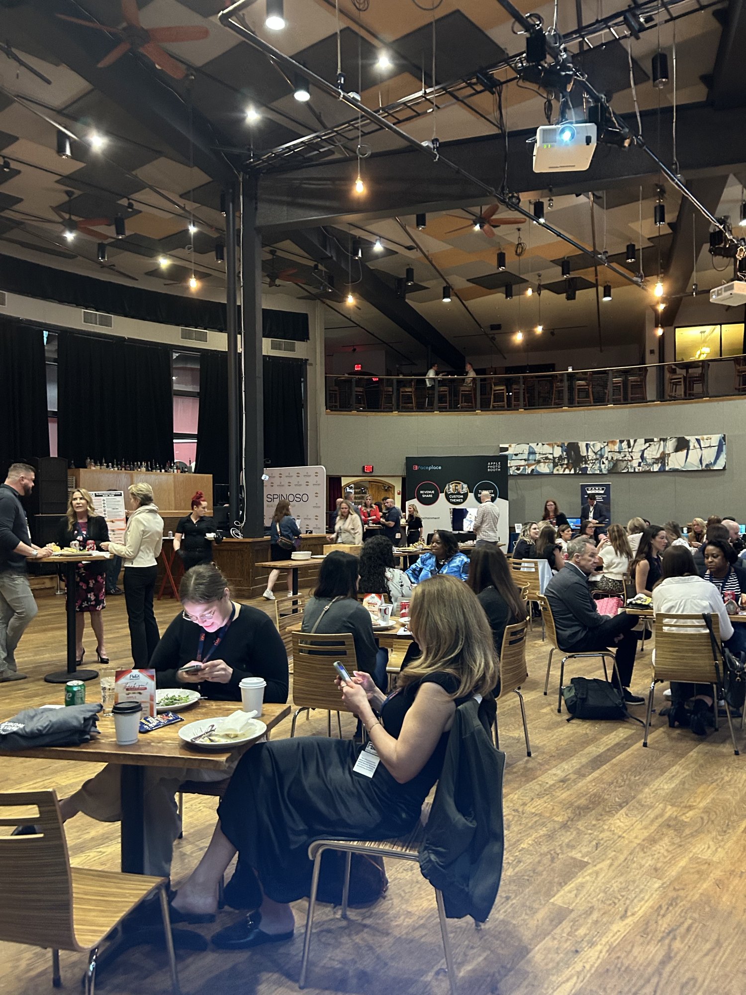 A full room of attendees at tables during a corporate event planned by Modern Client.