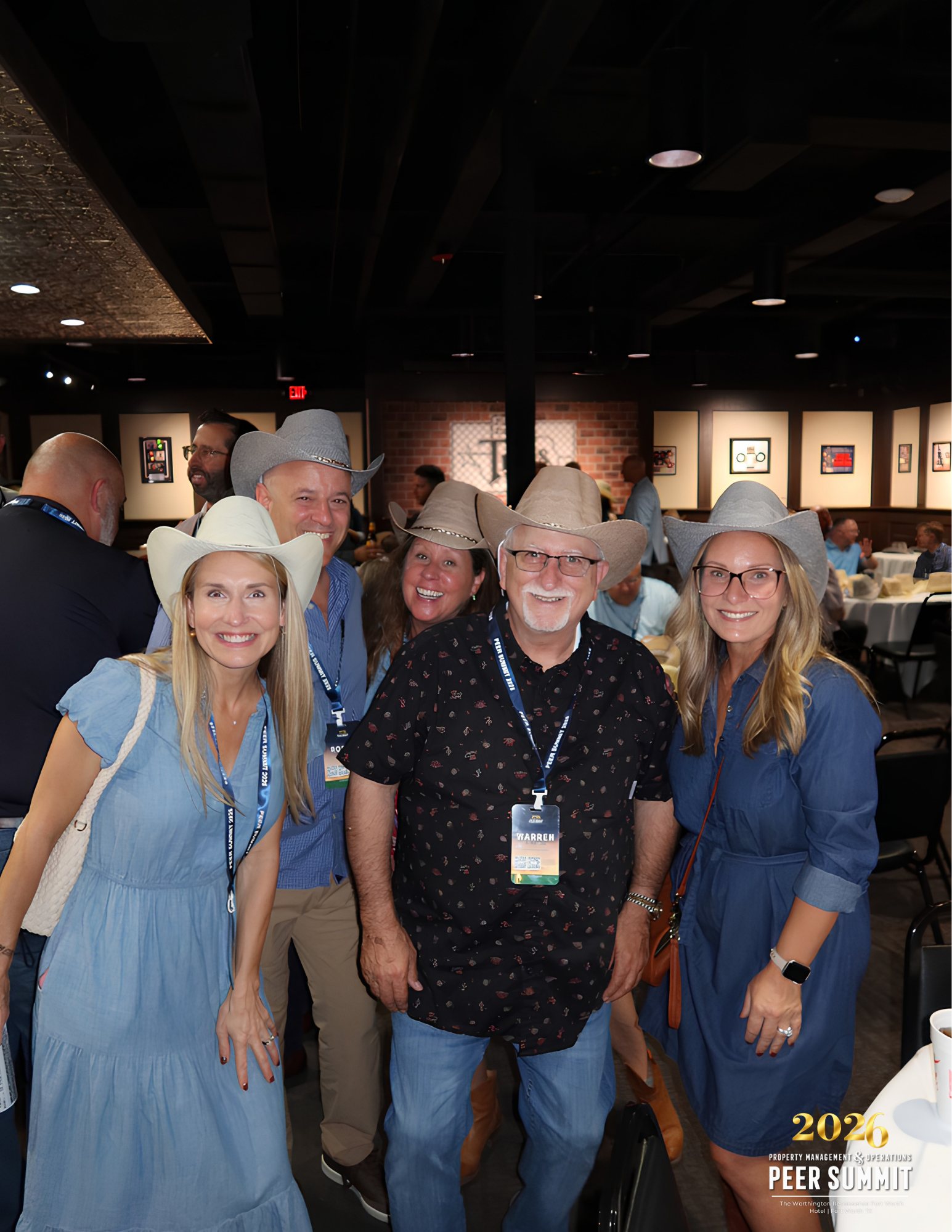 Peer group attendees in cowboy hats at Billy Bob's Texas in the Fort Worth Stockyards during the Property Management & Operations Peer Summit planned by Modern Client.